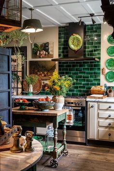 a kitchen with green tiles on the wall and wooden flooring, along with potted plants