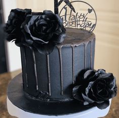 a birthday cake with chocolate frosting and black roses