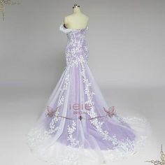 a white and purple wedding dress on display in front of a mannequin's head