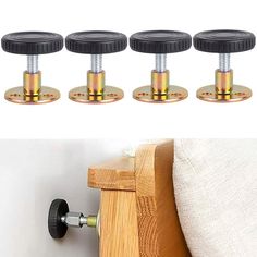 four black casteors on the side of a bed and three wooden posts with metal knobs