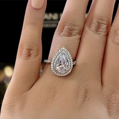 a woman's hand with a diamond ring on top of her finger and an engagement band