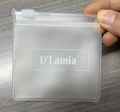 a hand holding a plastic bag with the name d'lamia on it