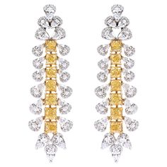 18 Karat Gold 13.31 Carat Yellow and White Diamond Solitaires Cocktail Earrings An imperial pair of earrings that exudes royalty and showcases the finest craftsmanship, this pair features 'Intense Yellow Diamonds'. Designed in an exquisite drop style, it features 7 Yellow Cushion-Cut Diamonds set in prong settings. Each yellow diamond consists of a Pear-Shaped Solitaire Diamond on either side. The top stud creates a dramatic look with two pairs of Solitaire diamonds with one diamond placed above Luxury Yellow Diamond Earrings For Wedding, Luxury Yellow Diamond Drop Earrings, Luxury Yellow Diamond Cut Earrings, Luxury Yellow Cubic Zirconia Earrings, Formal Yellow Earrings With 17 Jewels, Yellow Earrings With 17 Jewels For Formal Occasions, Luxury Chandelier Earrings For Formal Occasions, Luxury Yellow Gold Chandelier Earrings For Anniversary, Luxury Chandelier Earrings For Anniversary