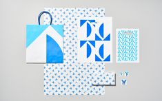 several pieces of paper with blue and white designs on them, including an origami style bag