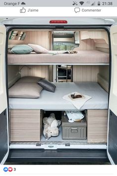 the interior of a camper van with two beds and storage compartments on each side