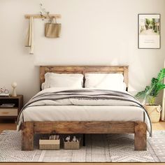 a bed sitting on top of a wooden floor next to a white wall in a bedroom