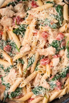 a pasta dish with spinach, chicken and parmesan cheese in a skillet