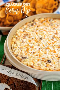 baked corn dip in a casserole dish with crackers and chips on the side