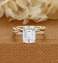 an emerald cut diamond ring on top of a box