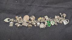 Incredible vintage / antique charm bracelet. 26 unique charms: 1.Frying pan with an egg. Stamped "Sterling". 2.February Pisces charm with two fish and "February". Stamped "Sterling". 3.A skateboard with moving wheels. Stamped "Sterling". 4.Double, baby shoes, charm. Jeweler verified as Sterling Silver.  5.A mailbox charm, with a heart on the front and moveable flag. Stamped "Sterling". 6.Double hart charms. Stamped "Mexico". Jeweler verified as Sterling Silver.  7.A comedic pig cartoon figure, holding u one finger and holding a shovel or cement spatula. It is stamped with a copyright symbol. Jeweler verified as Sterling Silver.  8.LaMode Guilloche Enamel Rose Heart Charm with a mint green background. Stamped "Sterling" and "LAMODE".  9.A four-leave clover with dark green enamel work. Stamp Luxury Metal Charm Bracelet With Vintage Charm, Victorian Sterling Silver Charm Jewelry, Antique Silver Charms Jewelry For Anniversary, Heirloom Silver Bracelet With Vintage Charm, Heirloom Silver Jewelry With Vintage Charm, Silver Heirloom Jewelry With Vintage Charm, Elegant Vintage Charms For Collectors, Antique Metal Charm Jewelry, Antique Metal Charms Jewelry