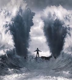 a man standing on top of a surfboard in the middle of a large wave