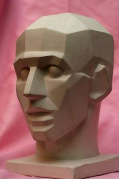 a paper sculpture of a man's head on a pink background