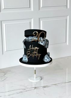 a black and gold birthday cake with money on top