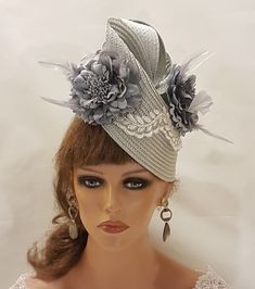 SilverGrey Hat Fascinator with Feathered Flowers, perfect for Royal Ascot, Kentucky Derby, Weddings Goodwood revival, Christening, Ascot or any special occasion. Gorgeous  Silver grey straw weave Hat fascinator with  SilverGrey Silk flowers adorned with a beautiful Leaf motif to the front  **Do you like to have this in any other custom colours, Please message. if possible with the dress picture* This hat has been made by hand and very light to wear. This hat is designed to be worn tilted on the side of the head with  long  Quill feather and the Flowers with feather detail for a beautifull Glamorous look. Attachment option: Alice band (BY DEFAULT HEADBAND WILL BE BLACK SATIN COVERED. IF YOU LIKE TO HAVE IN BROWN,BEIGE/CREAM, SILVERGREY OR OTHER COLOURS PLEASE ADD A NOTE AT CHECKOUT) Groom Hat, Grey Fascinator, Mother Of Groom, Hat Fascinator, Goodwood Revival, Satin Noir, Floral Hat, Alice Band, Mother Of Bride