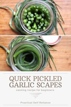 two jars filled with green garlic on top of a wooden table