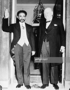 two men in suits and ties are standing on the steps with their hands up to each other