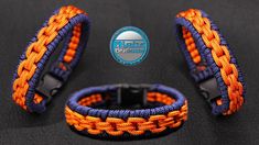 two orange and blue braided bracelets with an emblem on the front, one is black