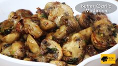 a white bowl filled with cooked mushrooms covered in sauce and seasoning next to a sign that says butter garlic mushroom