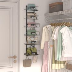 an organized closet with clothes and handbags hanging on the rack, next to a door