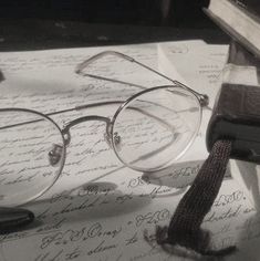 a pair of glasses sitting on top of an open book