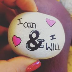 a person holding a rock with the word i am and i will written on it