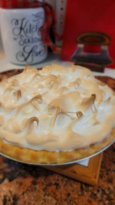 a pie sitting on top of a counter next to a cup