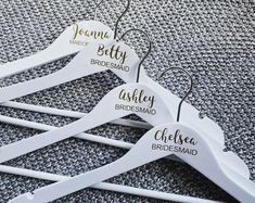 four personalized wedding hangers with names on them