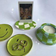 a couple of plates with rings on them next to a candle holder and photo frame