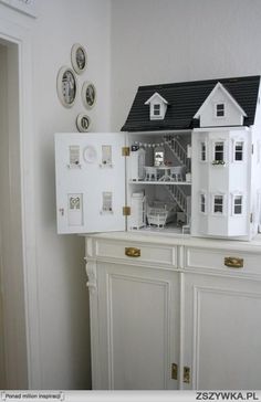 a doll house on top of a white cabinet