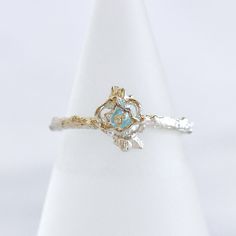 "This is a Vi Ling classic piece. An intricate rose ring with vine detailed band crafted in sterling silver. A faceted blue topaz rondelle is a keepsake inside the rose bud with a tiny cubic zirconia stone that adds sparkle to this unique detailed ring. Customization is available.  choose your ring size 3/8\" x 3/8\" rose length  blue topaz; cubic zirconia; sterling silver Handcrafted in Los Angeles Unless we have the size you request in stock, this item will be specially for you. Please feel fr Elegant Sterling Silver Ring With Rose Design, Elegant Promise Jewelry With Rose Design, Elegant White Gold Flower Ring With Birthstone, Silver Diamond Jewelry With Rose Design, Fine Jewelry Rose Design Ring, Elegant Sterling Silver Flower Ring With Birthstone, Gift Flower Ring With Rose Cut Cubic Zirconia, Elegant Rose Gold Flower Ring With Birthstone, Fine Jewelry Diamond With Rose Design