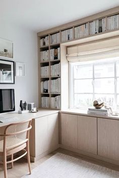 a desk with a computer on top of it next to a window