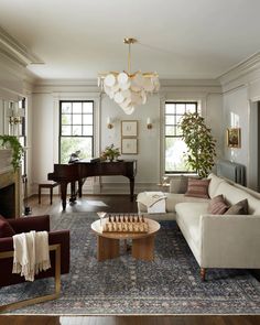 a living room filled with furniture and a grand piano in the corner on top of a blue rug