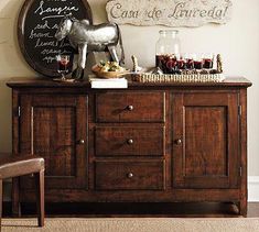 a wooden buffet table topped with lots of food and drinks next to a wall mounted chalkboard