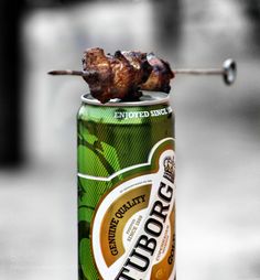 a can with some meat on top of it and a toothpick sticking out of it