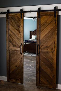 two wooden doors open to reveal a bedroom