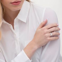 a woman wearing a white shirt and diamond ring