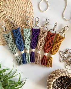 several different colors of key chains on a table next to a basket and potted plant