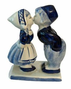 two ceramic figurines are kissing each other