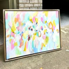 an abstract painting is displayed on the sidewalk