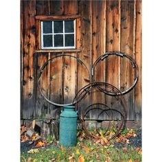 a metal sculpture sitting in front of a wooden building