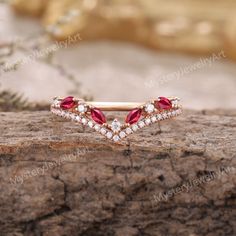 a diamond and ruby ring on top of a rock