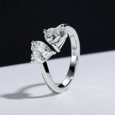 two pear shaped diamond engagement rings sitting on top of each other