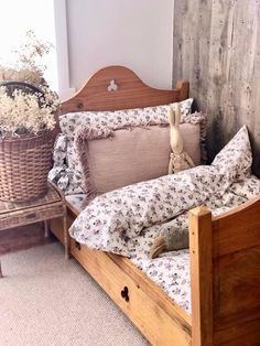 a bed that has some pillows on it and a basket with flowers next to it