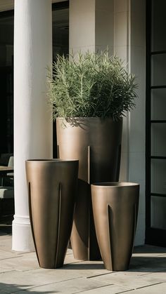 three large planters sitting next to each other on the ground in front of a building