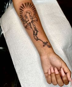 a woman's arm with a cross tattoo on it