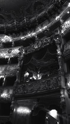 the interior of an old theater with chandeliers and stage lights on it's walls