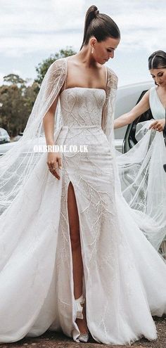 a woman in a white wedding dress is standing next to another woman wearing a veil