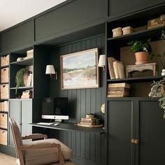 a home office with built in bookshelves and shelves