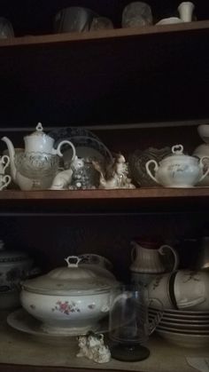 the shelves are filled with dishes and other decorative items, including cups and saucers