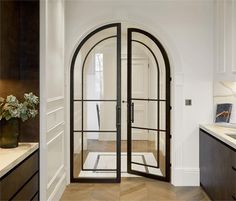 an arched glass door in a white kitchen